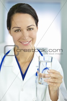 Smiling Woman Doctor in Hospital Holding Glass of Water