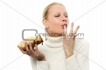 portrait of a young caucasian woman wearing a white turtleneck sweater and holding a slice of panettone