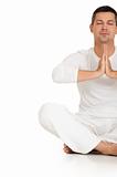 man dressed in white sitting on the floor practicing yoga