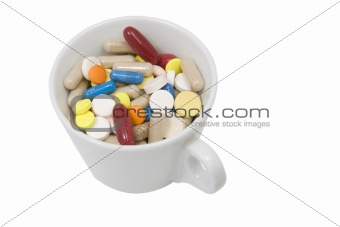 cup of multicolored tablets and capsules