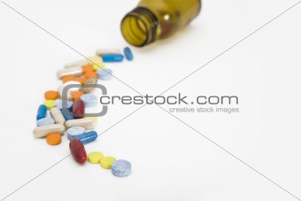 colorful stream of pills coming from a pill bottle