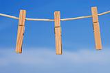 clothesline and pegs on blue sky background