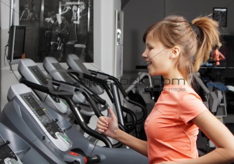 Young woman on exercise bicycle