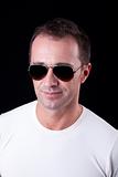 Portrait of a handsome middle-age man smiling with sunglasses, on black background. Studio shot