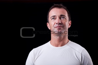 Portrait of a handsome middle-age man smiling, on black background. Studio shot