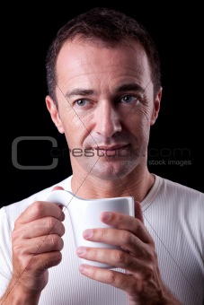 Portrait of a happy man, drinking a drink , isolated on black. Studio shot