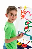 Young boy artist painting at easel
