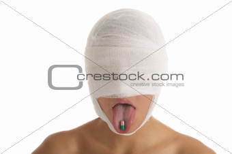 Young woman with bandaged head with tablet in tongue