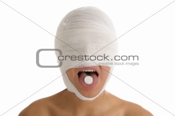 Young woman with bandaged head with tablet in tongue