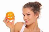 Woman holds orange with smile