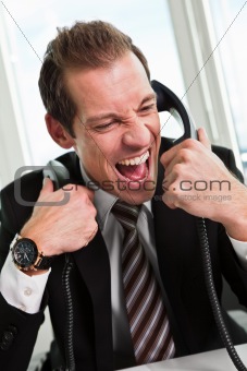 Stressed businessman screaming on the phone