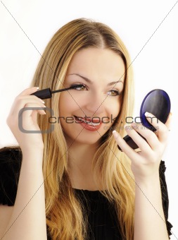 Beautiful woman applying mascara