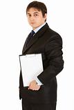 Pensive modern businessman holding blank clipboard in hands
