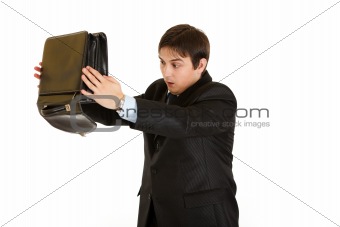 Shocked modern businessman searching  something in briefcase 
