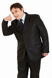 Smiling young businessman showing contact me gesture
