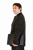 Smiling modern businessman holding laptops in hand
