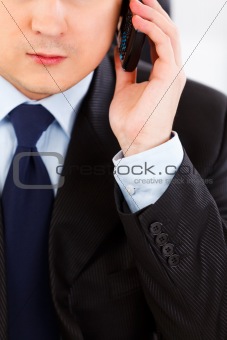 Concentrated businessman talking on mobile phone. Close -up. 
