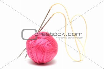 Pink clew and knitting needles isolated on white