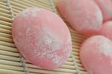 Pink Japanese rice cakes on bamboo mat