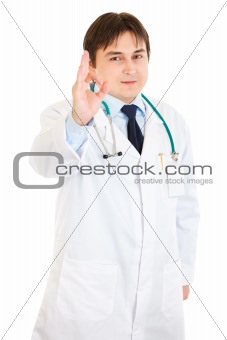Smiling young medical doctor showing ok gesture

