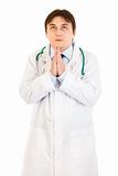Young medical doctor praying for success
