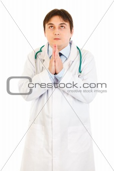 Young medical doctor praying for success
