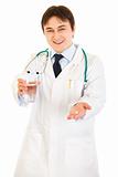 Smiling  medical doctor with drug and glass of water in hands
