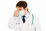 Tired medical doctor with mask on face
