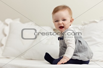 little girl sitting on bed and laughing