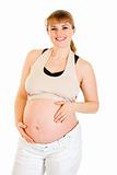 Smiling beautiful pregnant female holding her belly isolated on white
