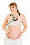 Smiling pregnant woman holding stethoscope on her belly
