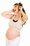 Happy pregnant woman listening music in headphones 
