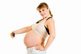 Smiling pregnant woman photographing her belly
