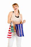 Happy pregnant woman holding shopping bags in hands
