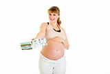 Smiling pregnant woman touching her belly and  holding present for  baby 
