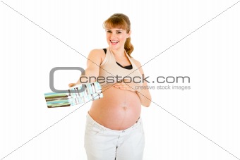 Smiling pregnant woman touching her belly and  holding present for  baby 
