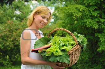 Young woman holding basket with vegetable