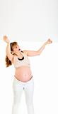 Smiling  pregnant woman holding blank billboard over her head

