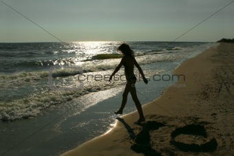 Silhouette of teenage girl on an empty beach