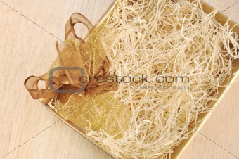 Open gift box and bow - filled with packing bast