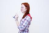 Redhead young woman is drinking from glass