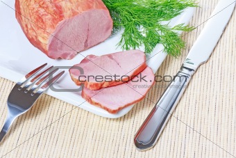 Smoked ham and dill on plate with knife and fork