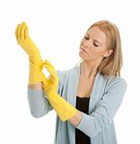 Cheerful housewife putting on gloves before cleaning