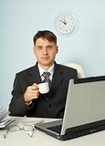 Little tired businessman drinking coffee in office