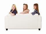 Three girls teens sitting on the couch