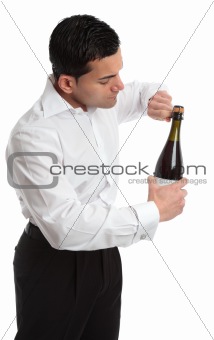 Sideview man or waiter opening bottle of champagne