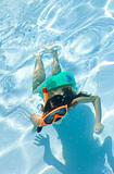 Girl Child Swimming Underwater in Pool with Goggles and Snorkel