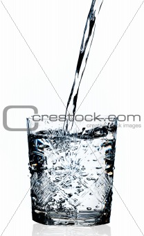 Water pouring in a glass, white background 