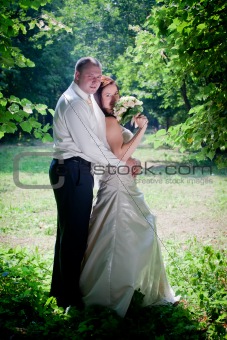 Newlyweds portrait in sunny summer park