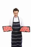 Butcher with trays of T-bone steak